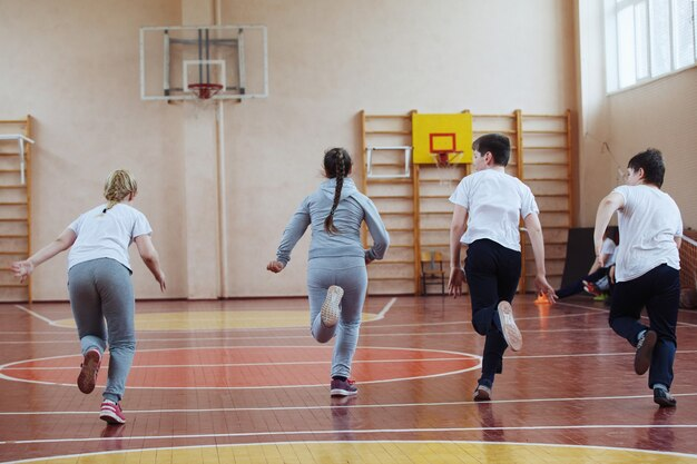 Students jogging in a row at the school gym.
